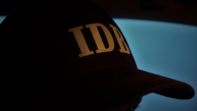 Attēls ar cepuri un IDB logo uz tās