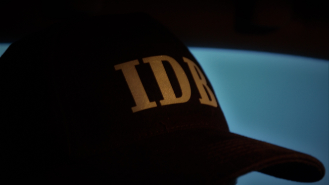 Attēls ar cepuri un IDB logo uz tās