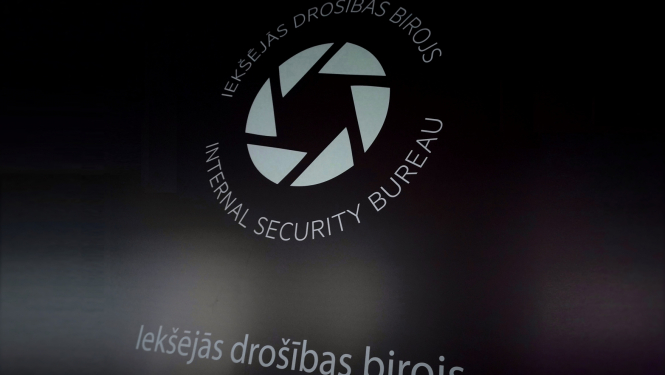 Attēls ar Iekšējās drošības biroja logo uz tumša fona