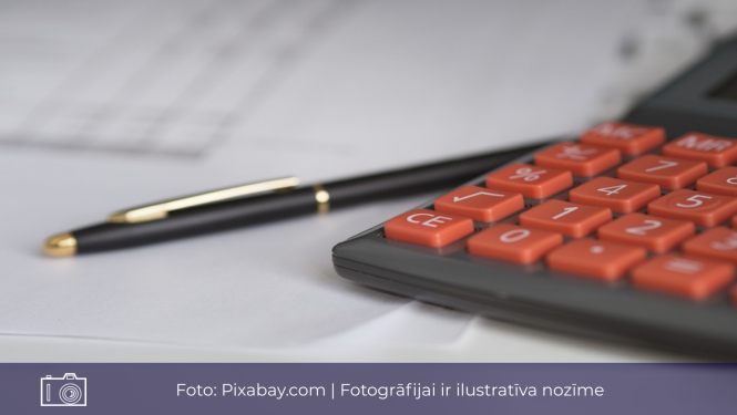 Attēls ar kalkulatoru, pildspalvu un lapām