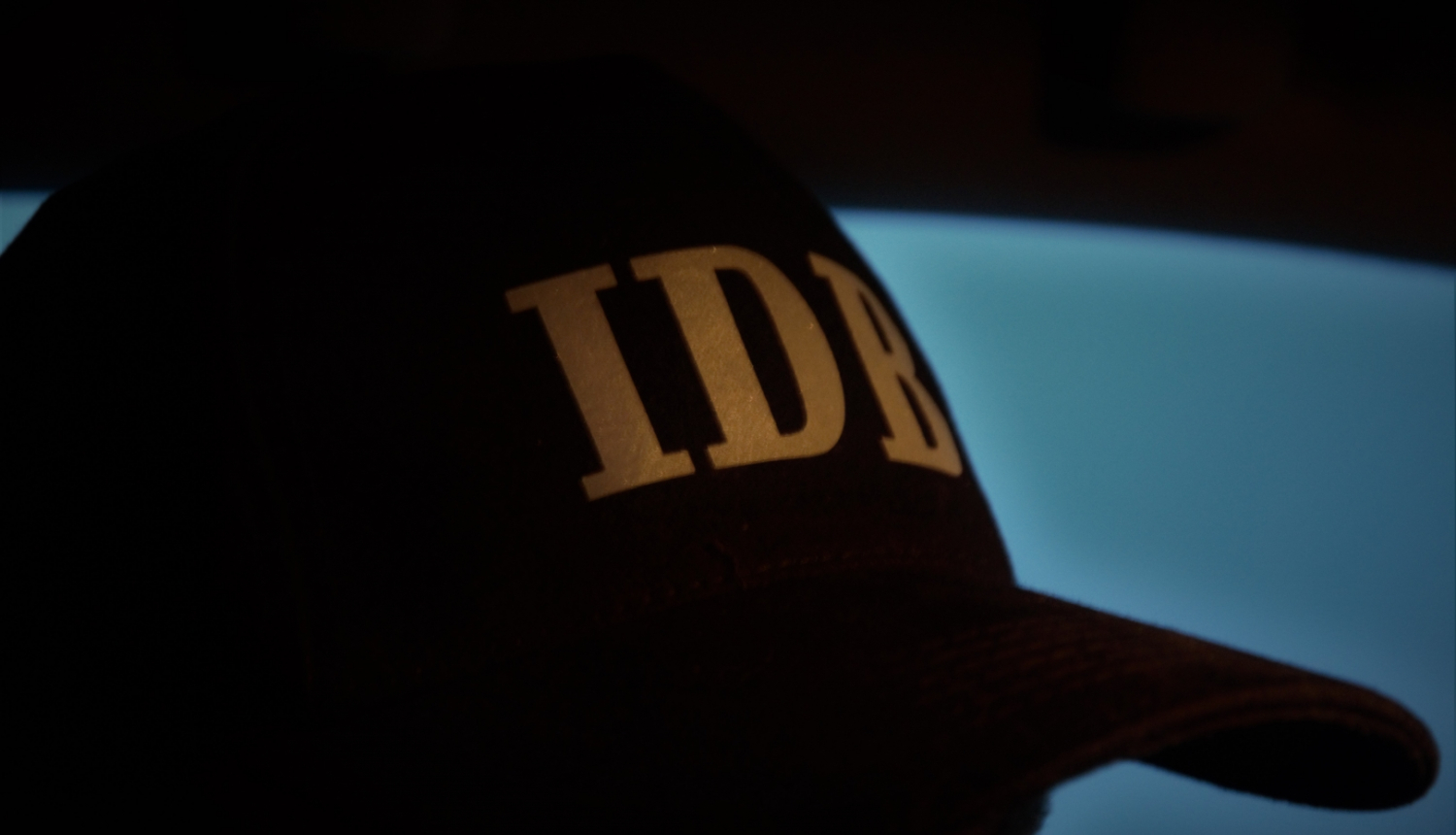 Attēls ar cepuri un IDB logo uz tās